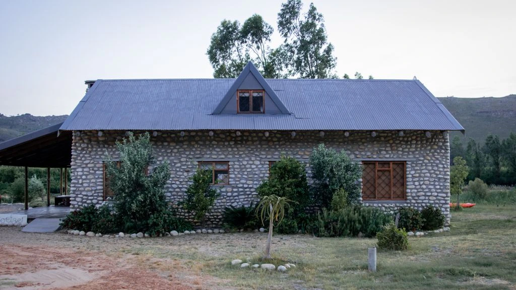 Intérieur d'une maison d'hôtes en Provence au crépuscule, lumière d'automne filtrant à travers des rideaux de lin